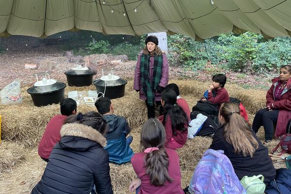 Students sitting around listening in a tent