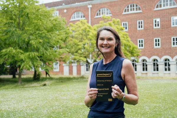 dawn burnham holds award sign for beyond gold green impact