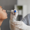 A teenager receives a COVID-19 test from a medical professional in PPE